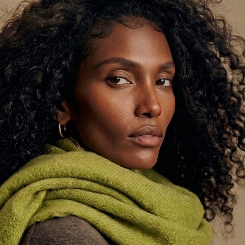 Model with curly hair in an olive alpaca scarf